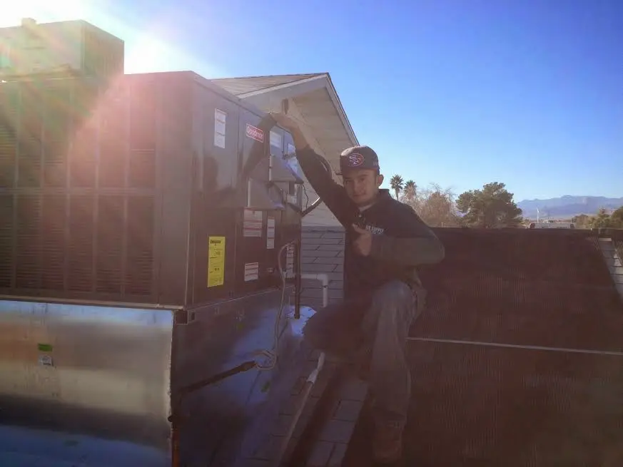 HVAC technician performing AC Tune-Up on a rooftop unit in Childress